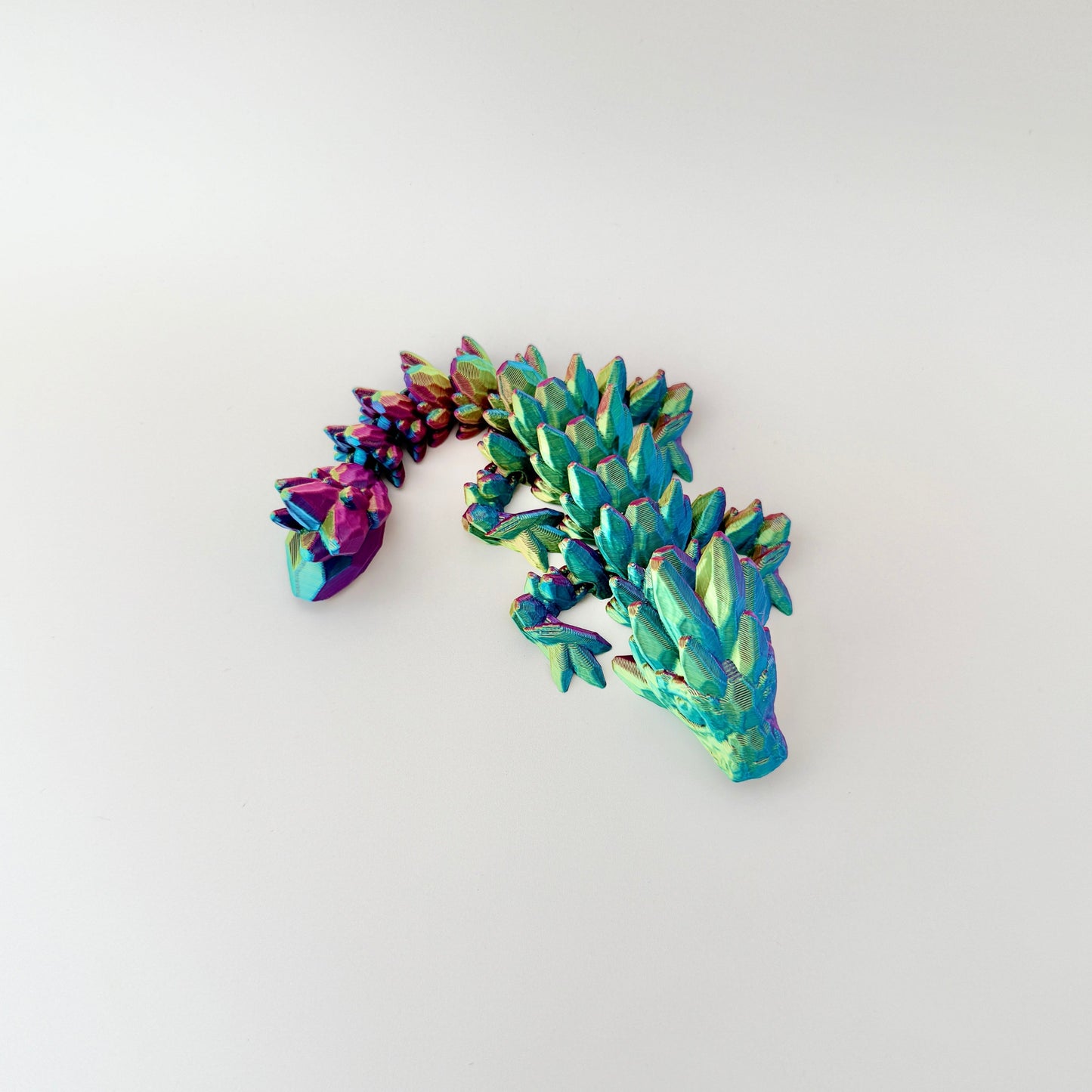 Small, articulated dragon fidget toy with colour-changing effects and flexible body for sensory play.