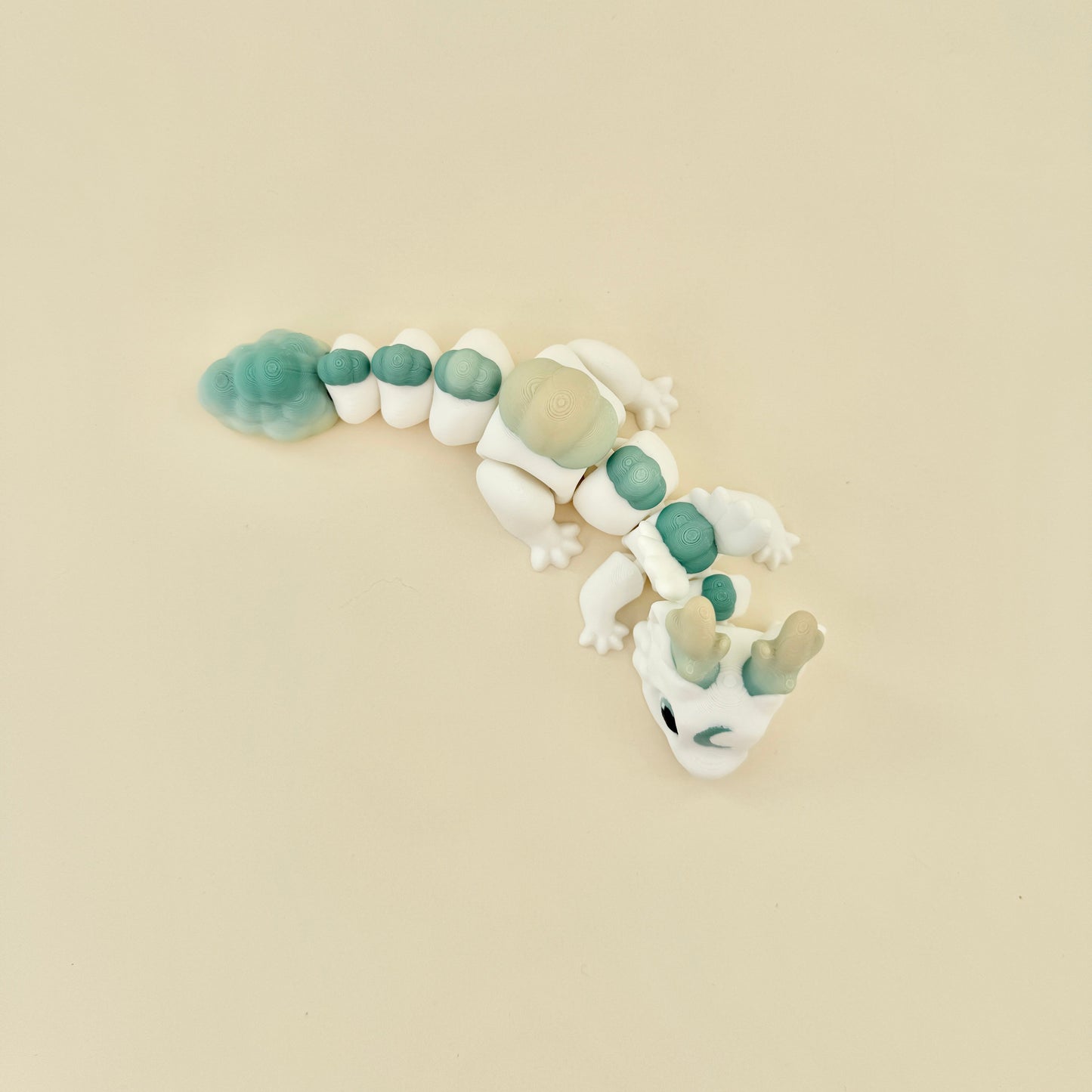 Dragon-style fidget toy with smooth segments and a subtle green and yellow gradient.