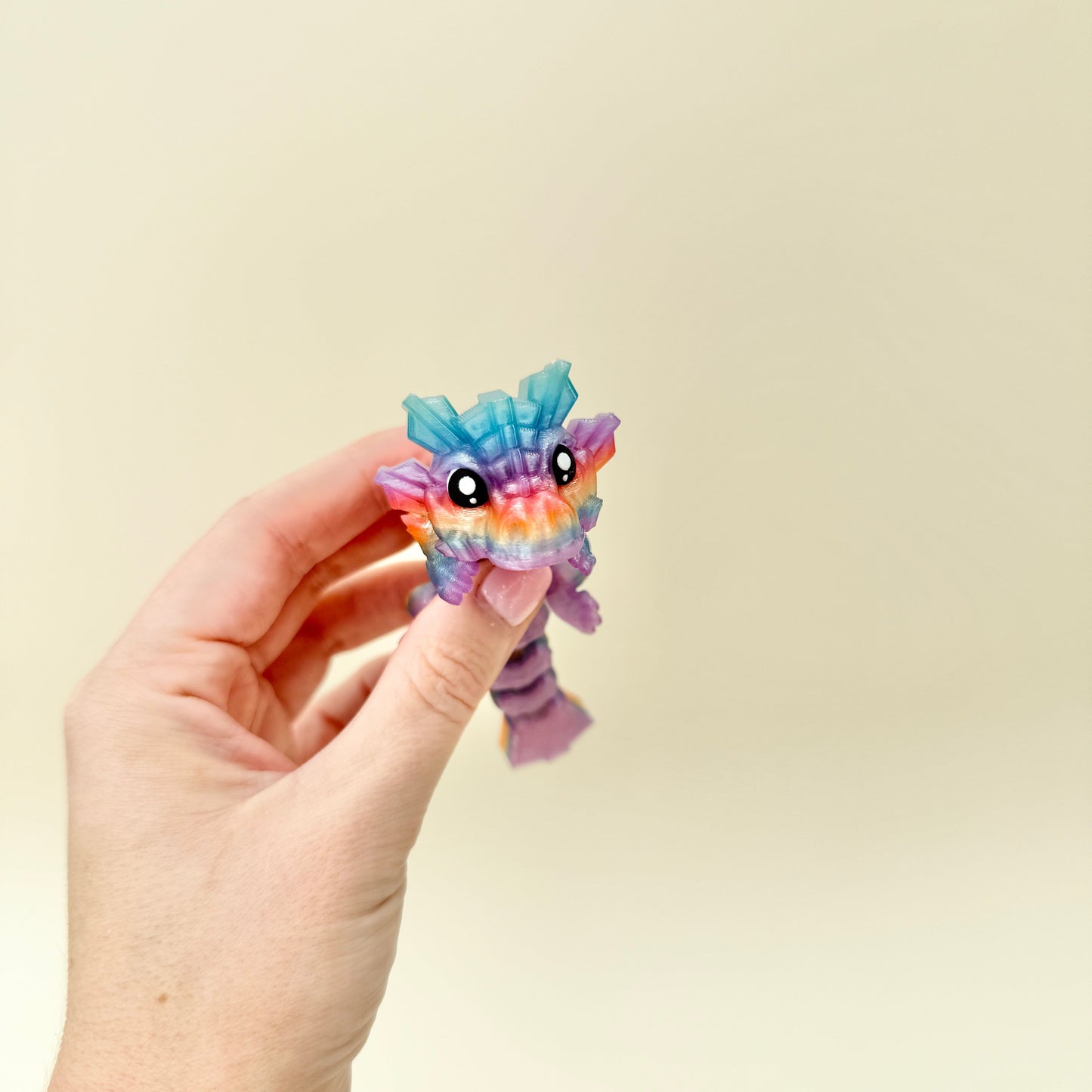 Limited edition rainbow dragon fidget toy with translucent colour and articulated body for sensory regulation.