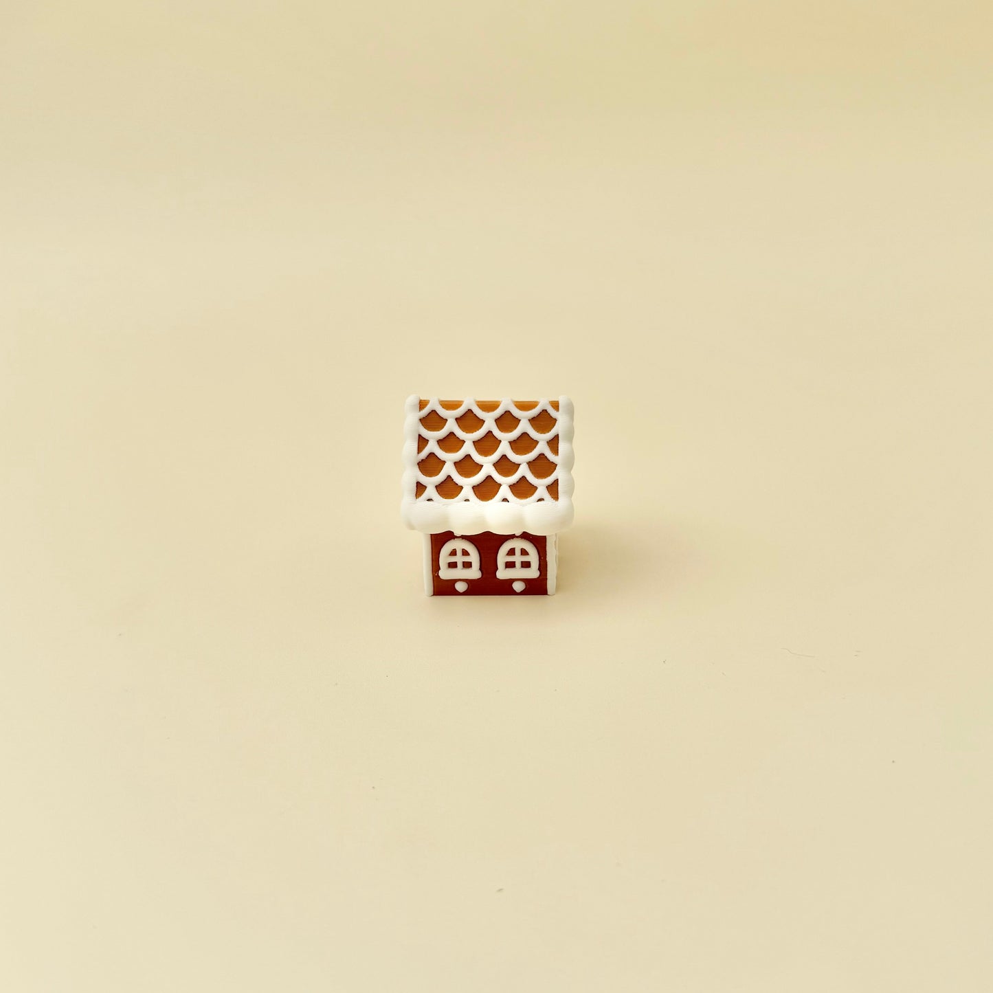 Mini gingerbread house desk toy; roof acts as the button for a satisfying click, tactile icing finish.