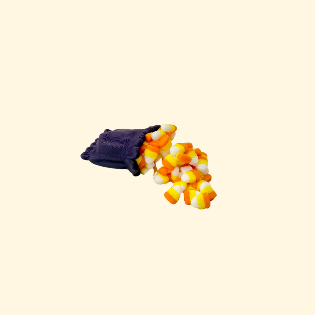 Small articulated candy-corn fidget with a mini sweet bag and flexible spill, approx. 5.4 cm.