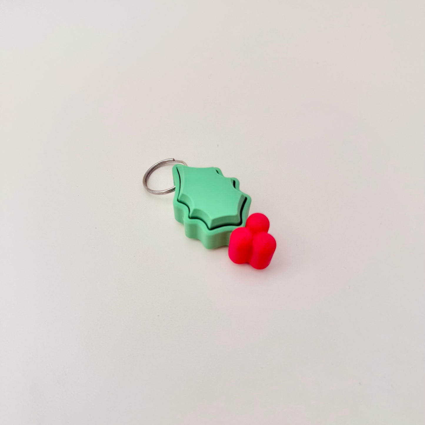Green holly leaf clicker with berries, 5 cm, attaches to keys or bags, optional quiet click.