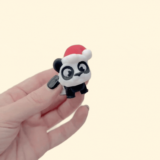 Mini 3D printed panda in red hat with poseable legs for light desk fidgeting.