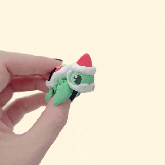 Compact articulated turtle with Santa-style shell, suitable for festive sensory play.