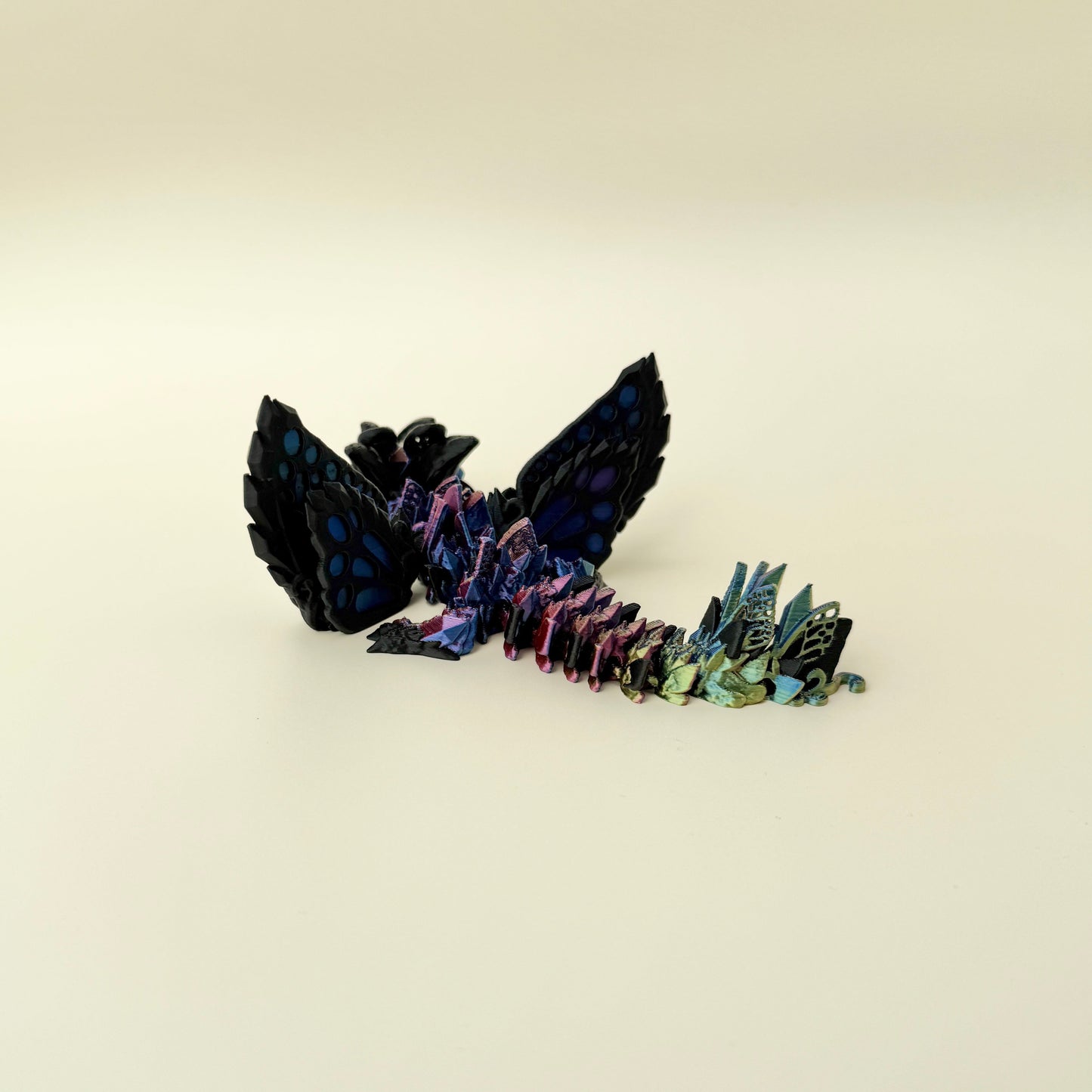 Hybrid dragon-wolf fidget toy with shifting metallic colour and butterfly elements