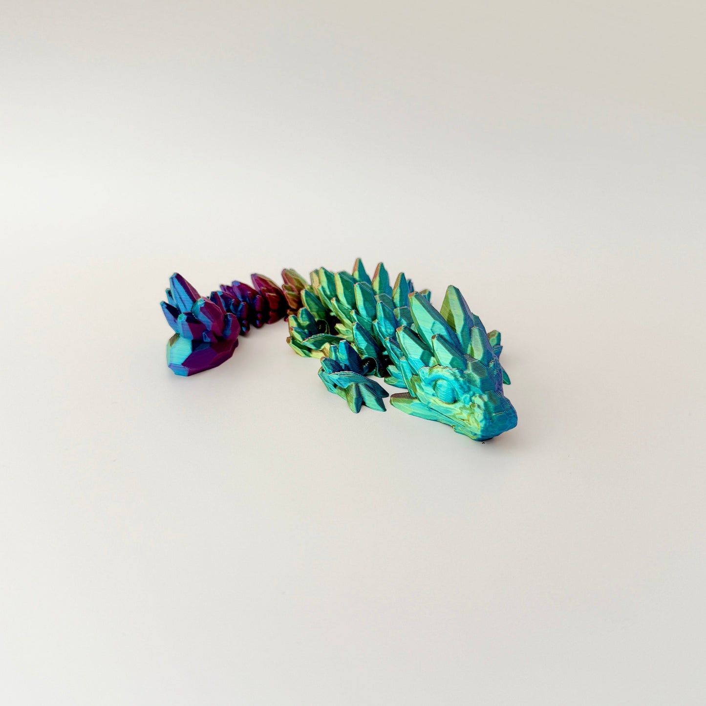 Articulated fidget dragon in dynamic colour-changing filament, measuring 18cm in length.