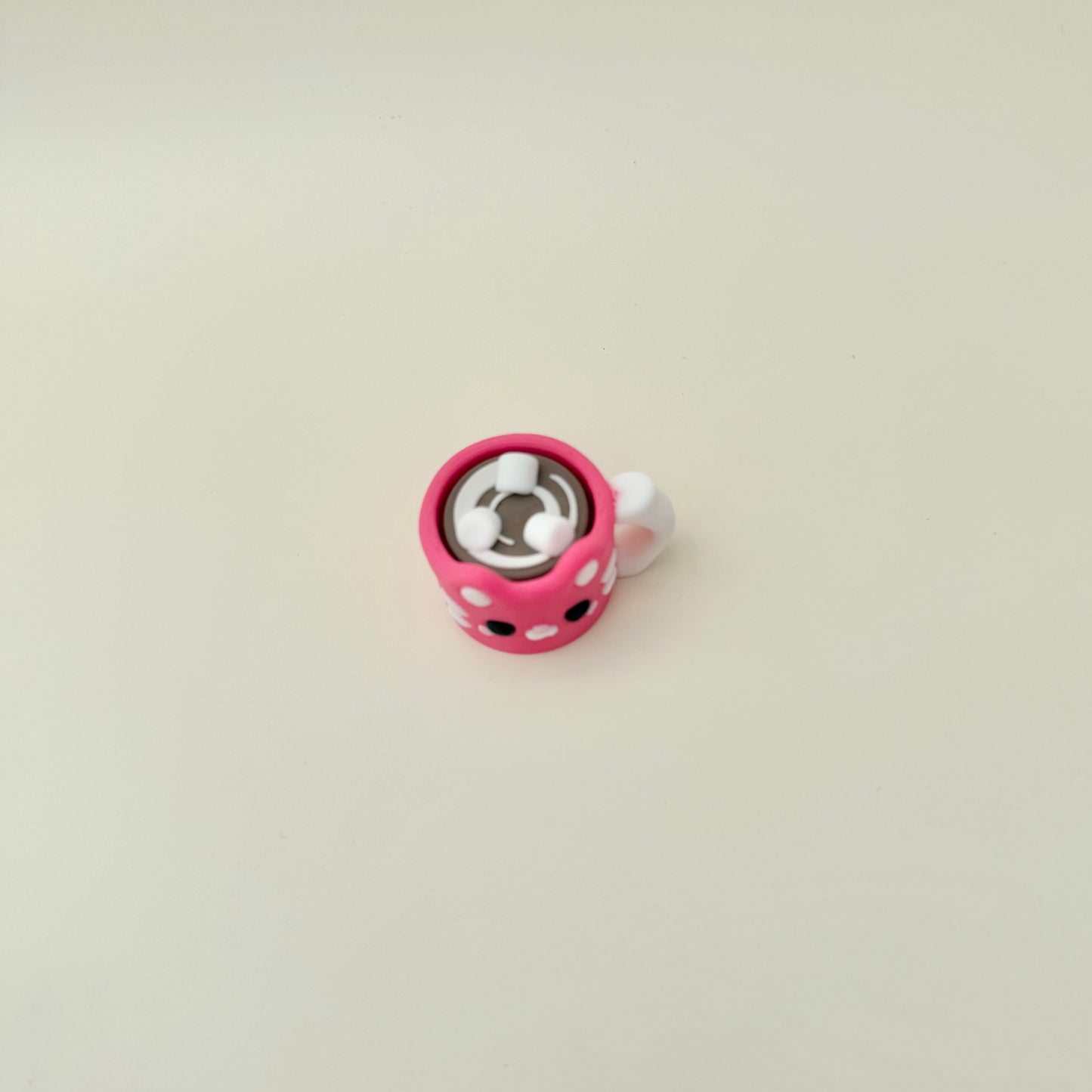 Pink winter-style mug toy with textured details for tracing and focus breaks.