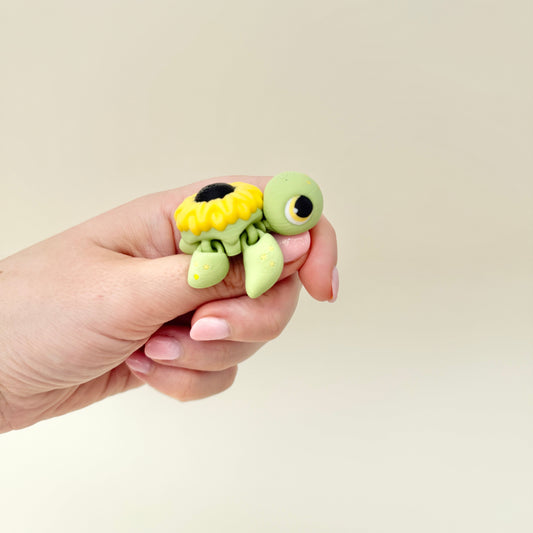 Small fidget turtle with a sunflower shell and moveable limbs, designed for tactile stimming and gifting.