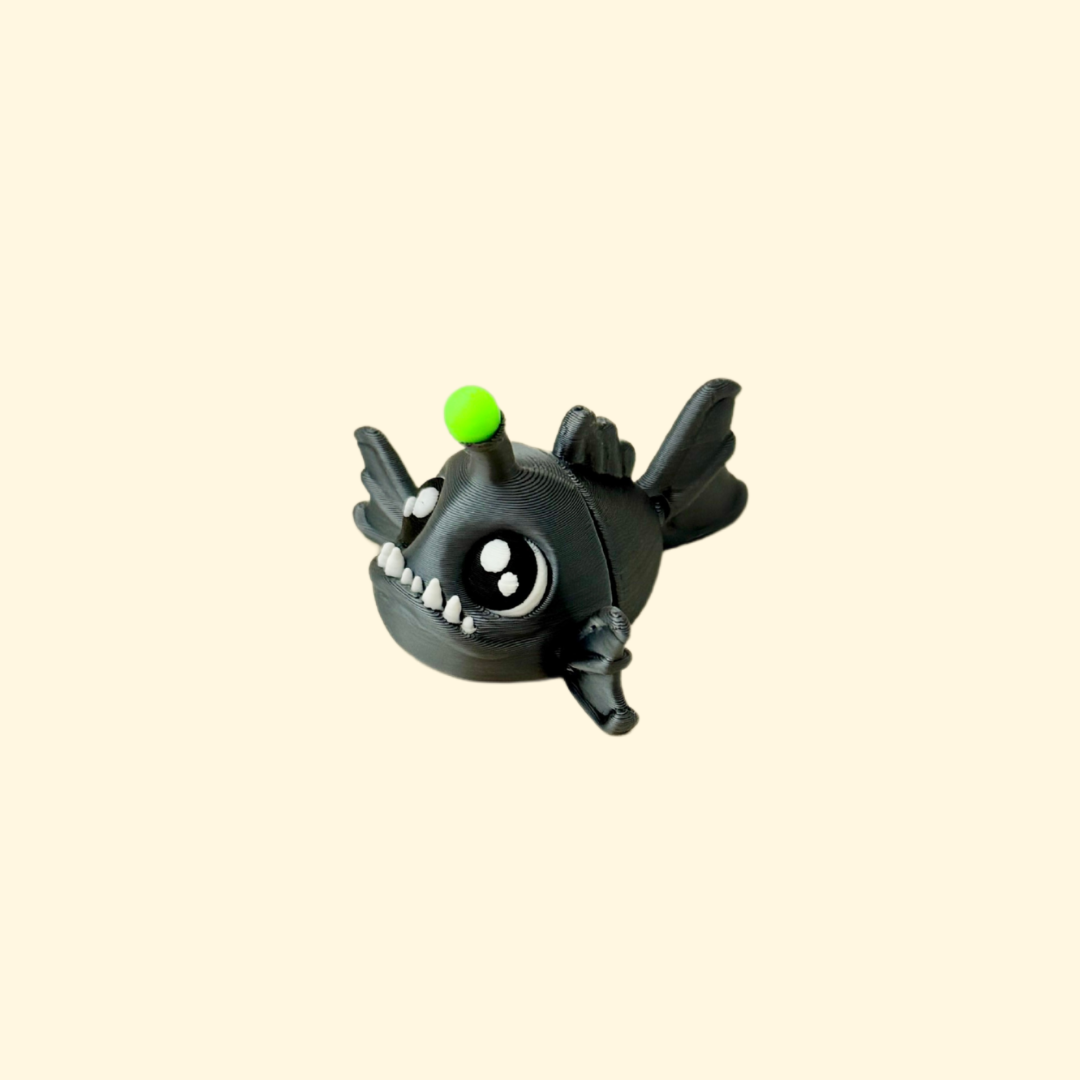 Small articulated fish fidget toy with a metallic finish and glowing green details