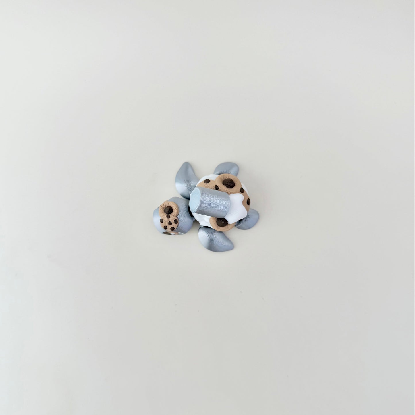 Collectible mini turtle fidget, 3D printed, cookies-and-cream theme, portable size for everyday stimming.