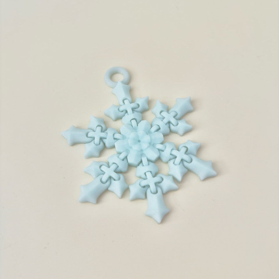 Ornament-style flexible fidget with an opening for tree, bag or lanyard attachment.