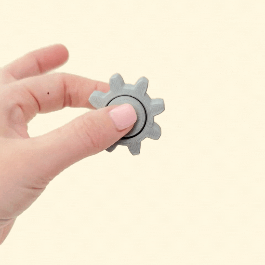 Metallic silver tactile spinner with cog-style rim for secure grip and balanced rotation for focus.