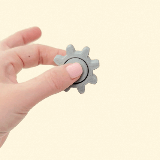 Metallic silver tactile spinner with cog-style rim for secure grip and balanced rotation for focus.