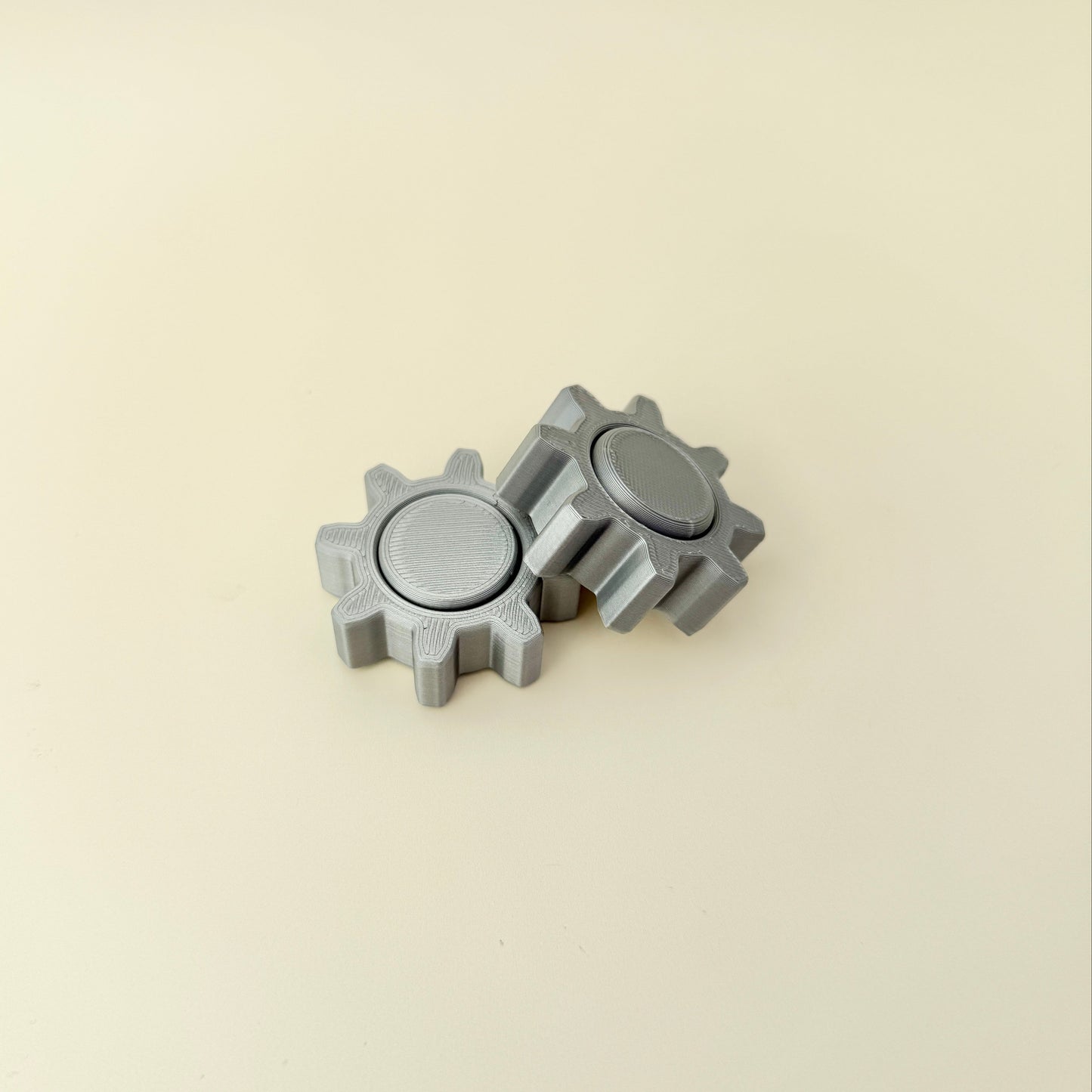 Small tactile spinner in cogwheel design; reliable low-noise spin for desk, class, or travel.