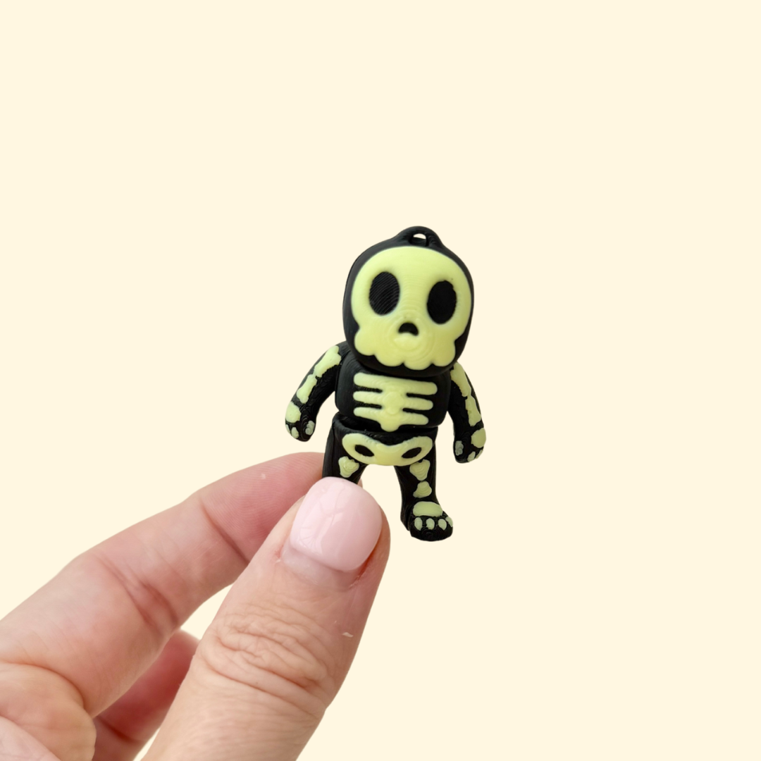 small skeleton-shaped fidget charm with glow accents and keyring loop