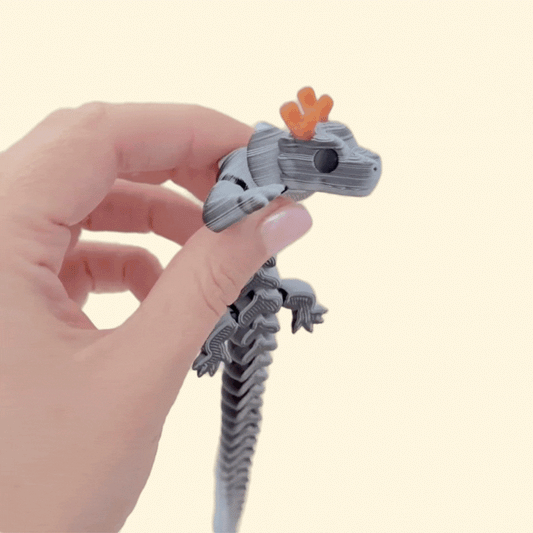 Articulated dragon fidget with textured segments and gold/bronze horn detail, smooth tactile motion for sensory use.