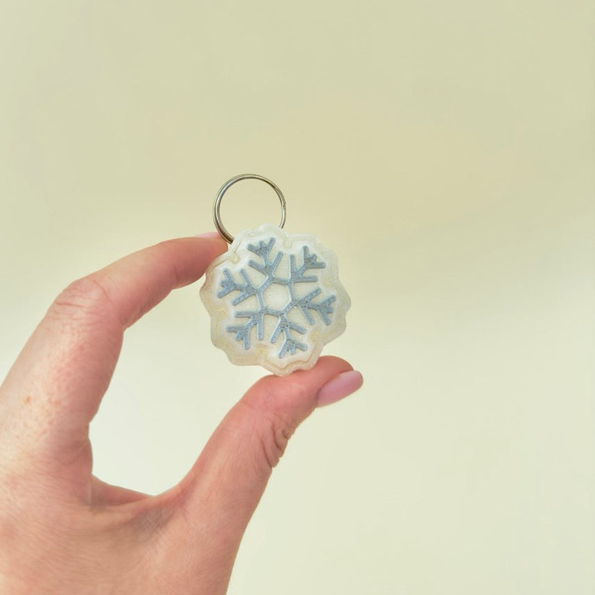 small festive clicker with subtle sparkle, keyring loop attached