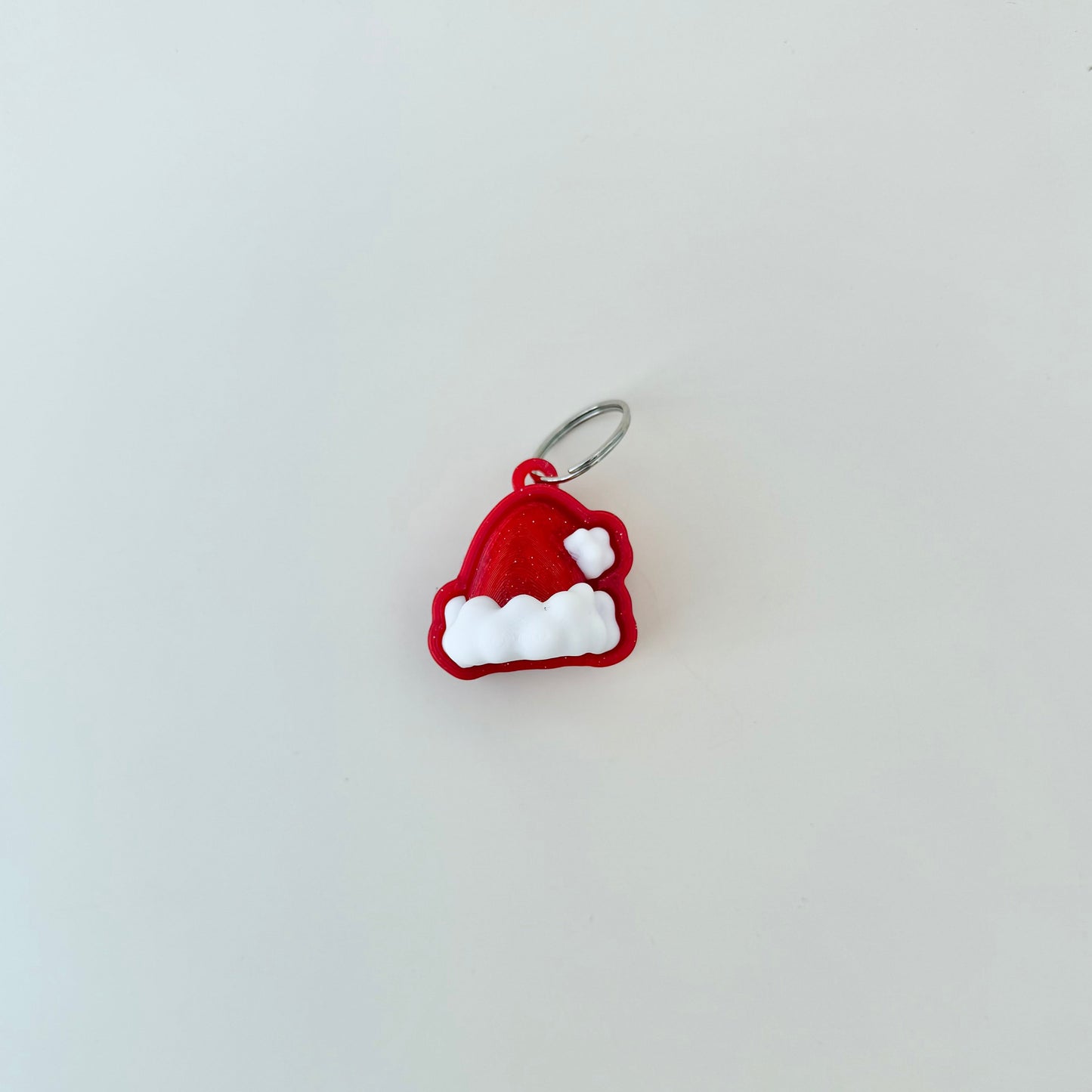 Christmas hat clicker designed for keys or lanyards; satisfying press with traceable details.