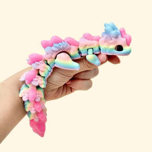 A colourful rainbow fidget dragon toy with bright pink sparkling accents and full articulation for sensory play.