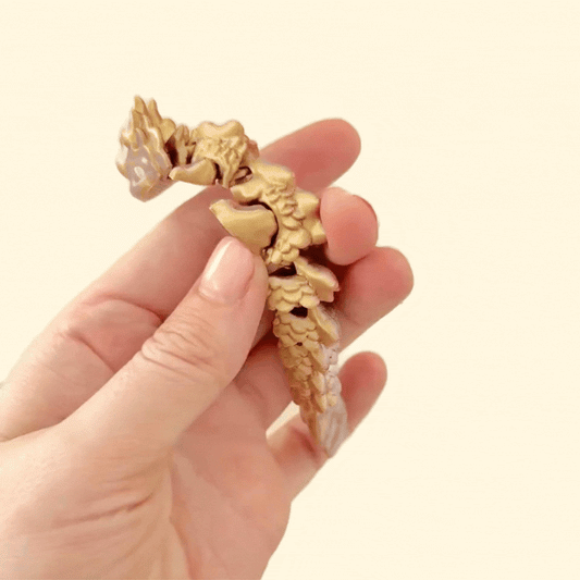 A fully articulated dragon fidget toy with a colour-changing blend of silver, copper, and gold.