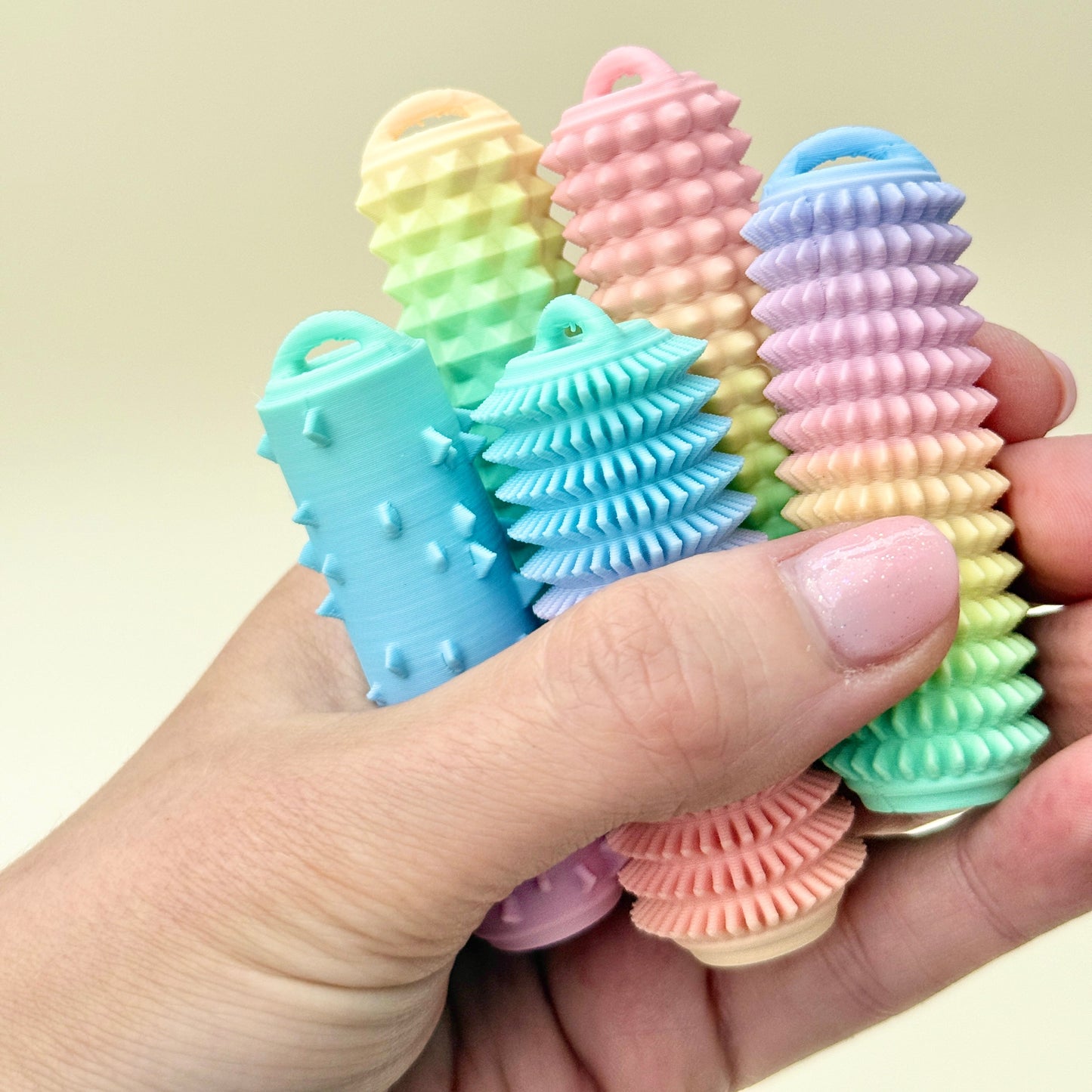 Nude-coloured palm stim tool with strap, used for stimming, self-regulation, and anxiety relief.