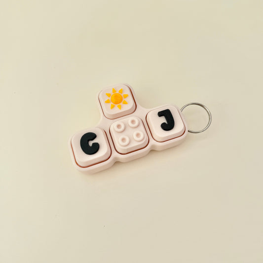Keychain with letters 'GO' and 'J' on a beige background