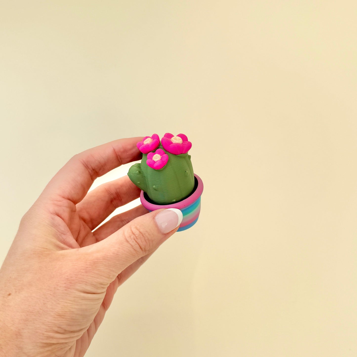 Cute cactus clicker with colourful base and textured surface for tactile feedback.
