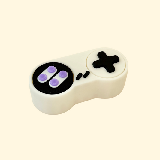 Sensory fidget toy inspired by vintage game controllers with built-in clickable buttons.