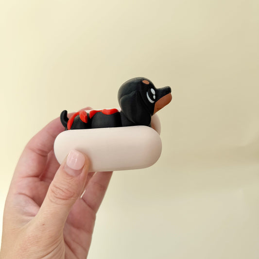 Poseable dachshund with textured bun; silent handheld fidget for focus and grounding.