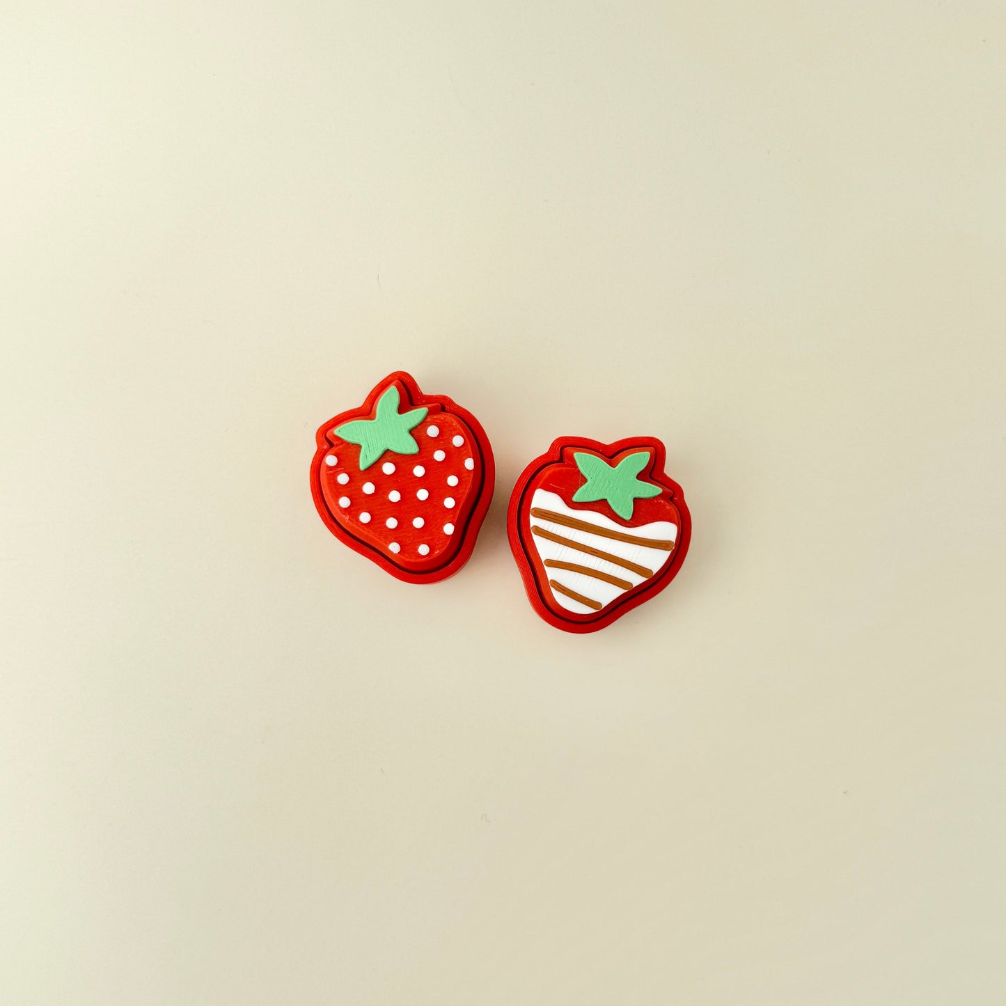 Compact strawberry-shaped clicker with textured detailing for sensory play.