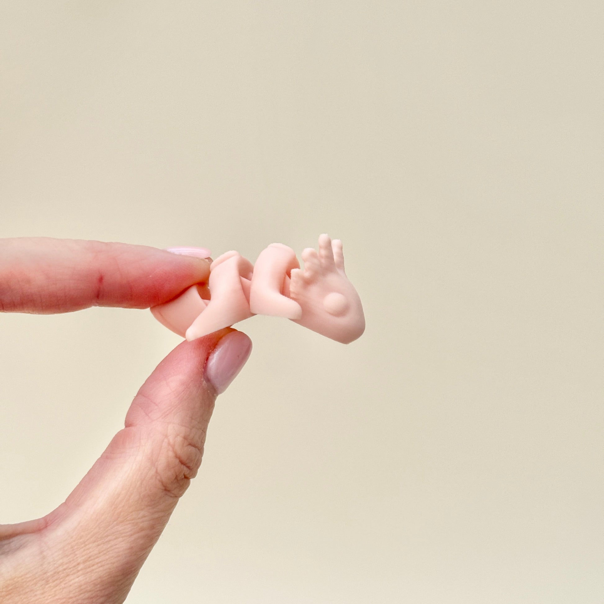 A SoftTone Mini Pet being held in a hand, demonstrating its compact, pocket-sized design for discreet fidgeting.