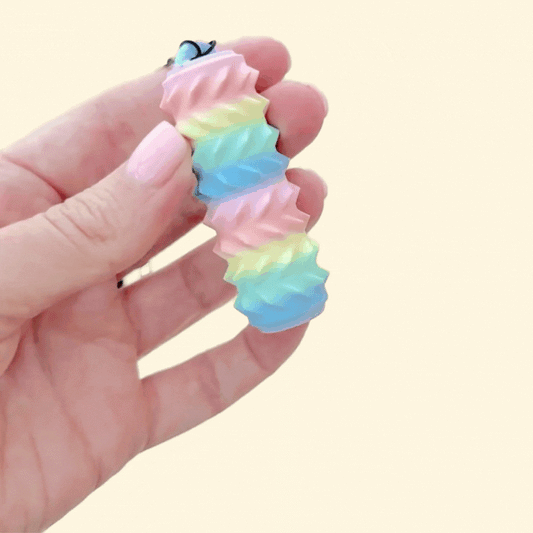 Handheld stim tool with removable strap for on-the-go sensory support.