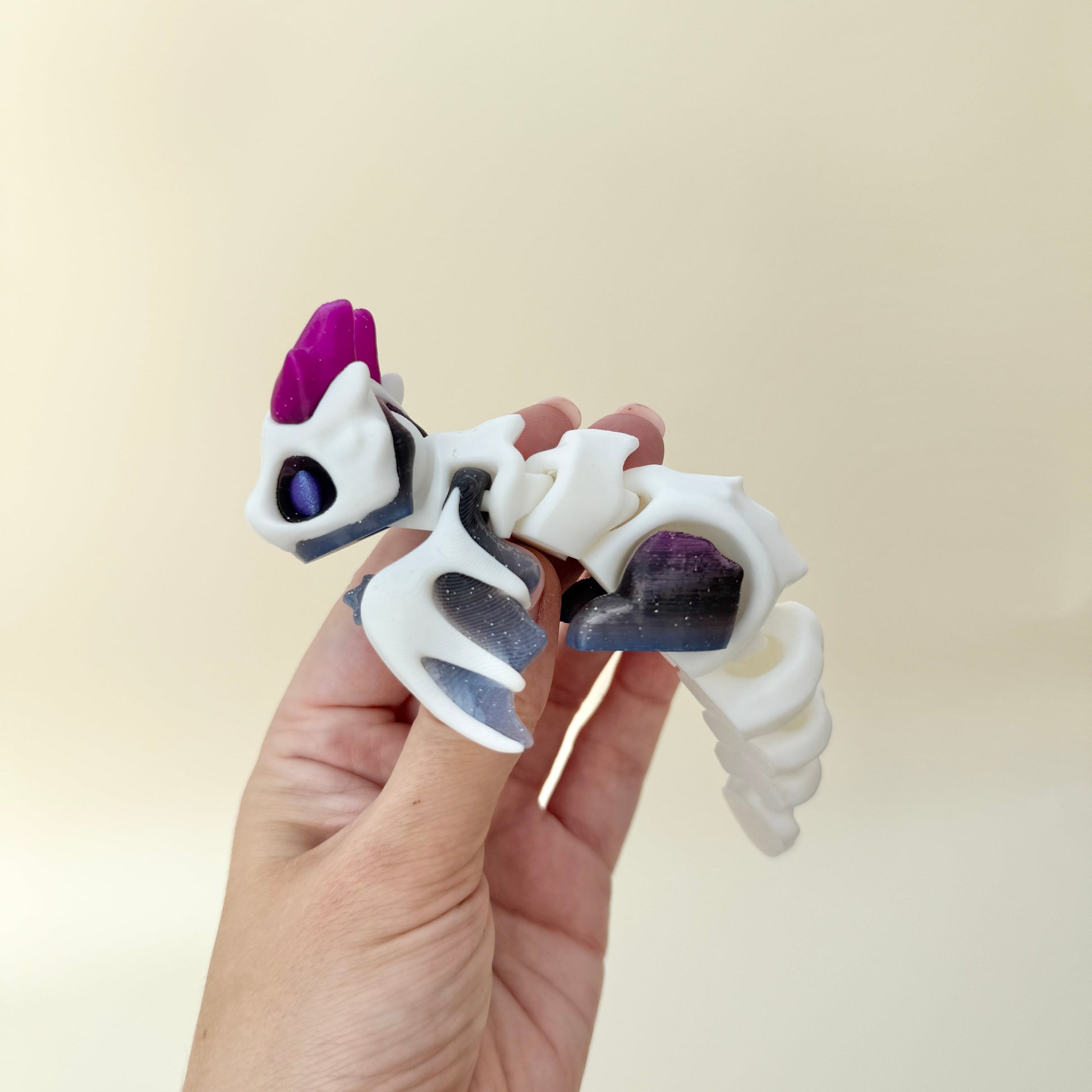 Quiet, articulated dragon fidget designed for thumb tracing and flowing movement; suitable for sensory regulation and display.