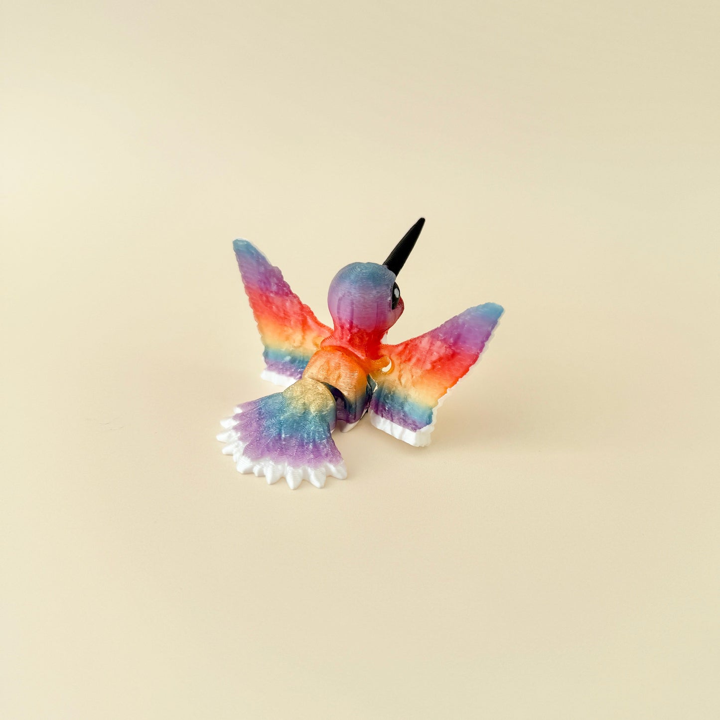 A beautifully detailed hummingbird fidget with white, red, and rainbow accents.