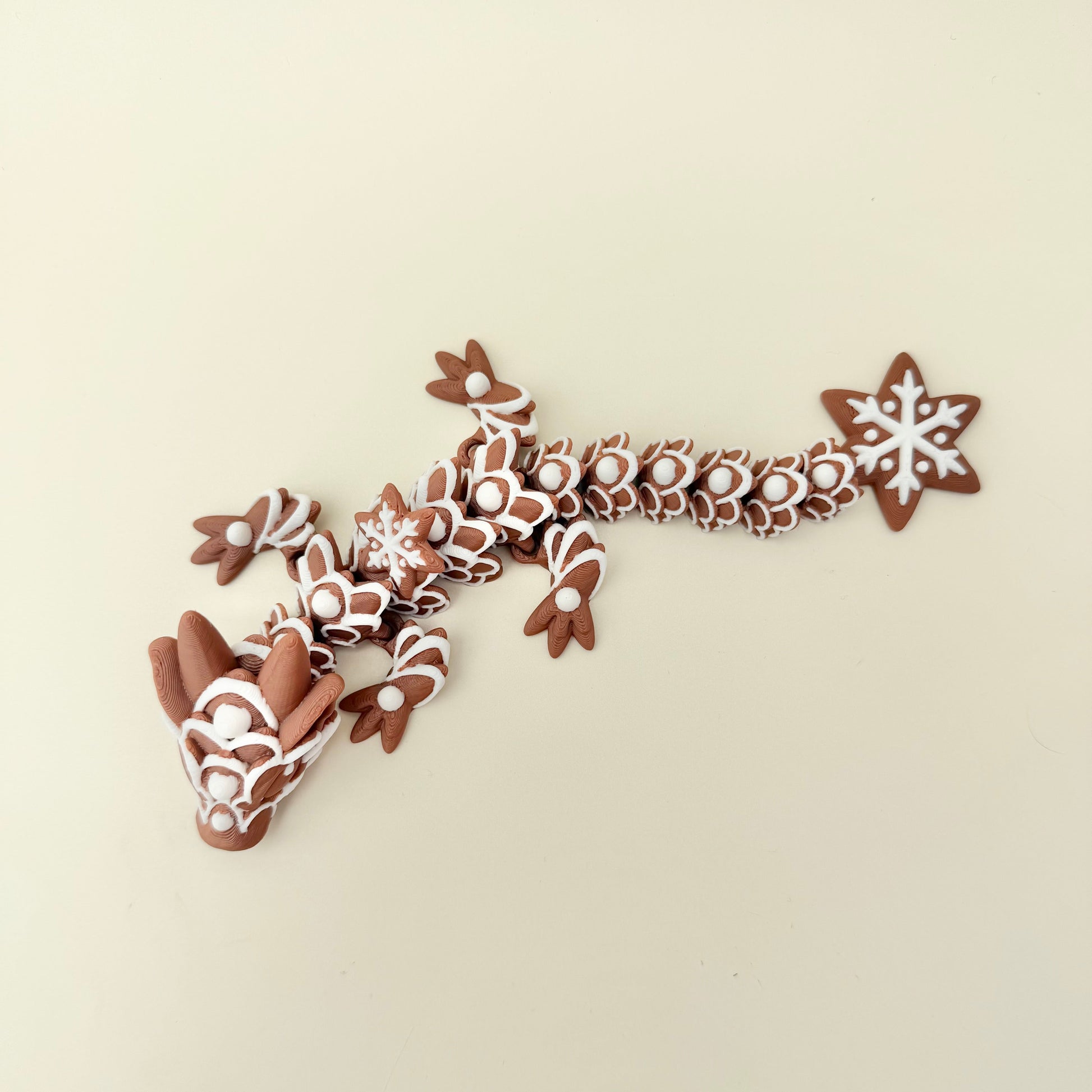 Gingerbread-inspired articulated dragon for sensory play and display.