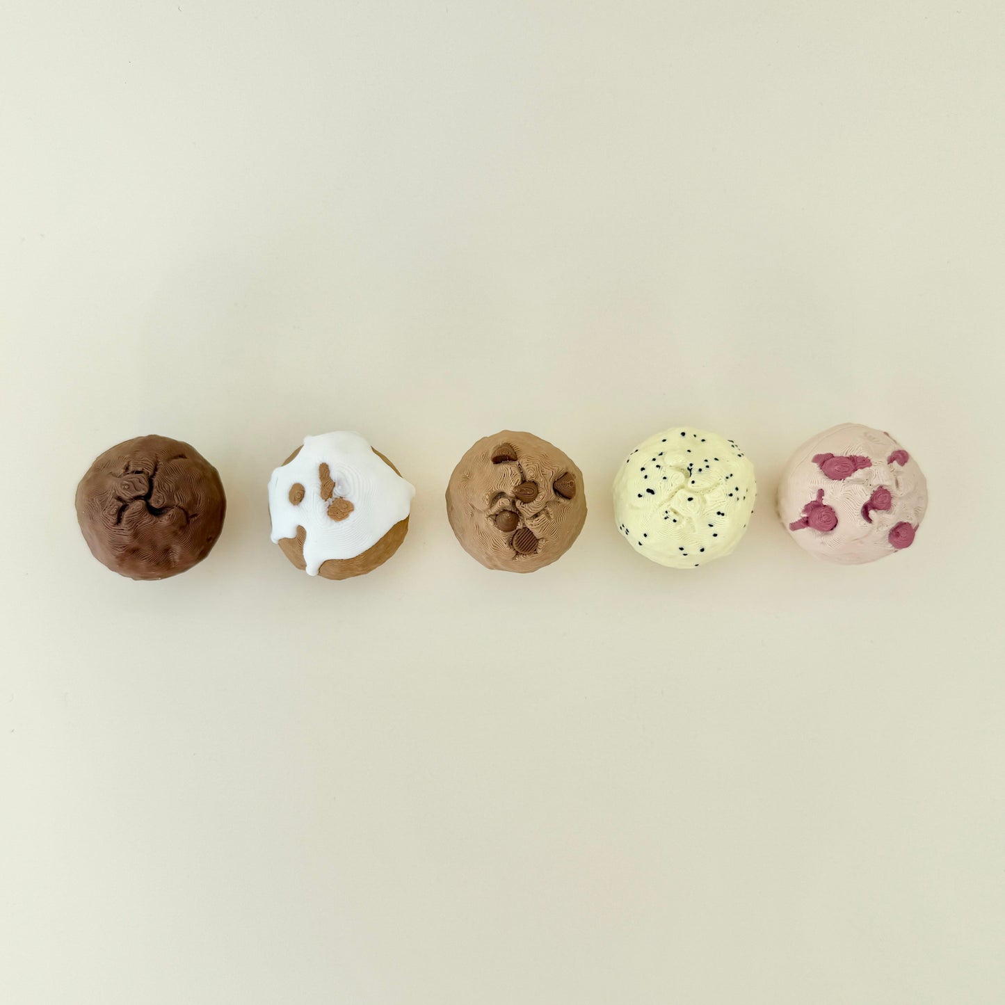 Clickable sensory toys styled like baked muffins, each with unique detailing.
