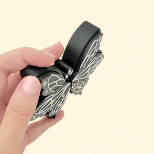 Black clicker toy featuring gold and white decorative accents