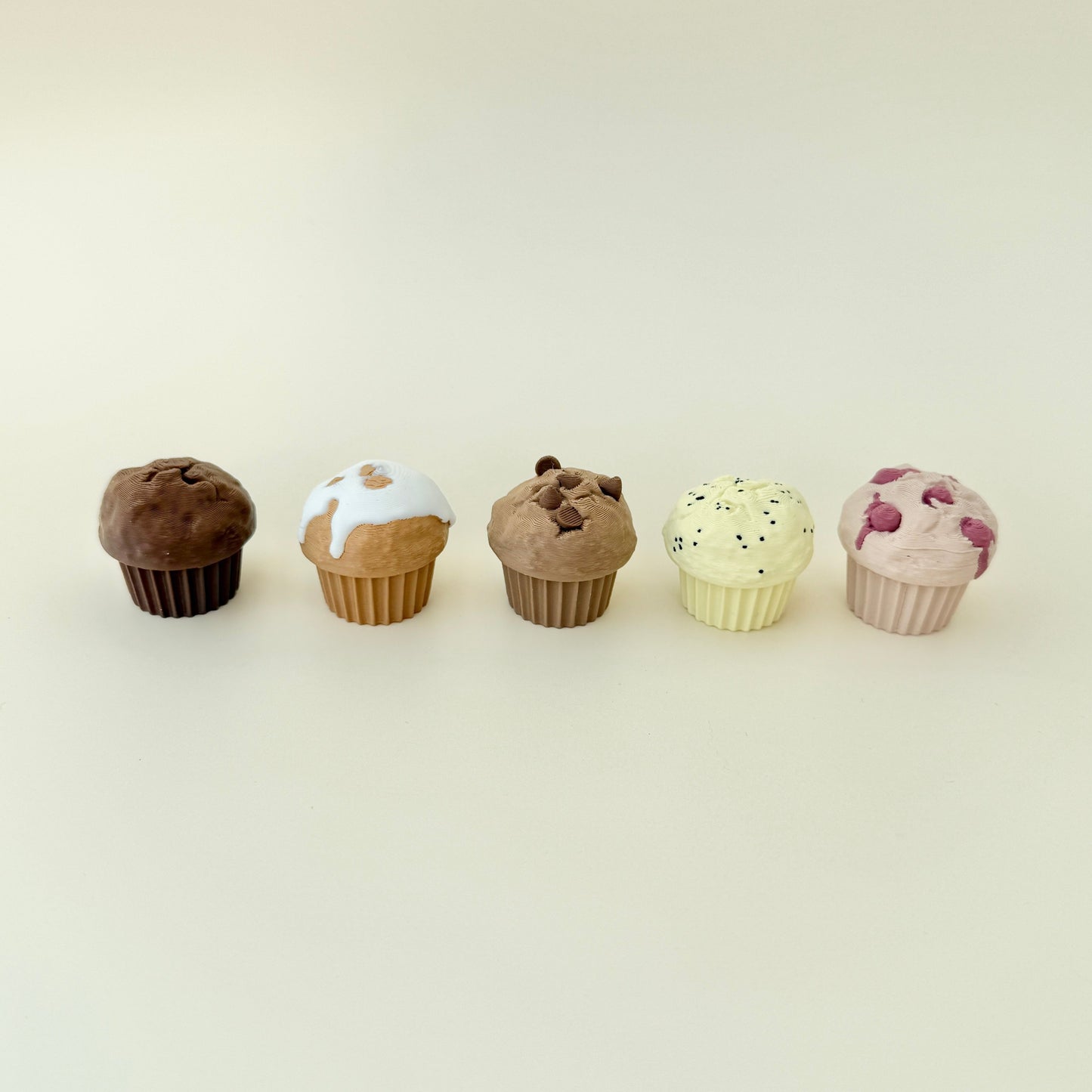 Mini muffin toys with raised icing, chips, or berries for sensory feedback.