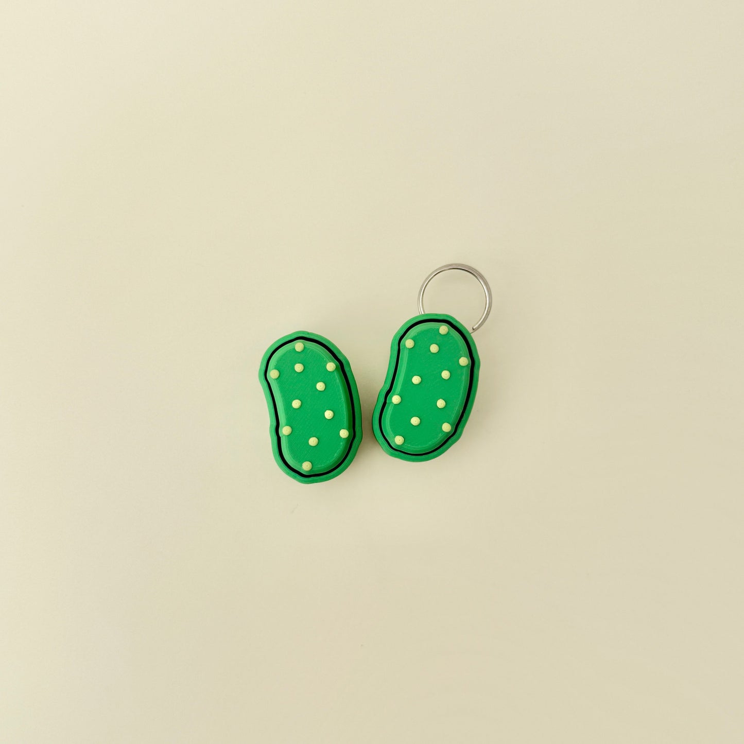Small green clicker toy with firm top and bumpy surface designed for tactile feedback.