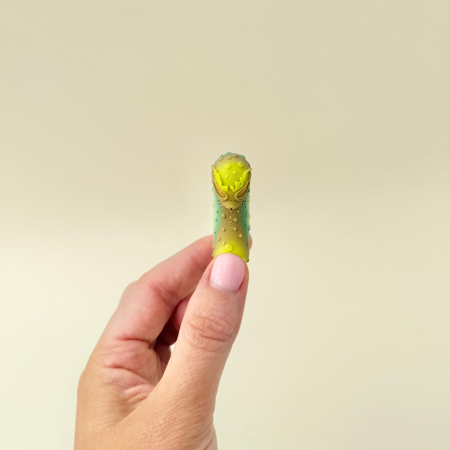 A compact textured pickle fidget that offers quiet tactile feedback and visual character.