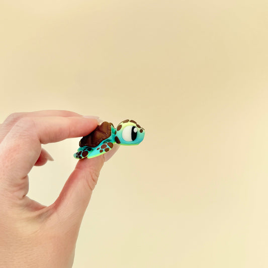 Baby sea turtle with brown shell, detailed body markings, and big eyes for sensory engagement.