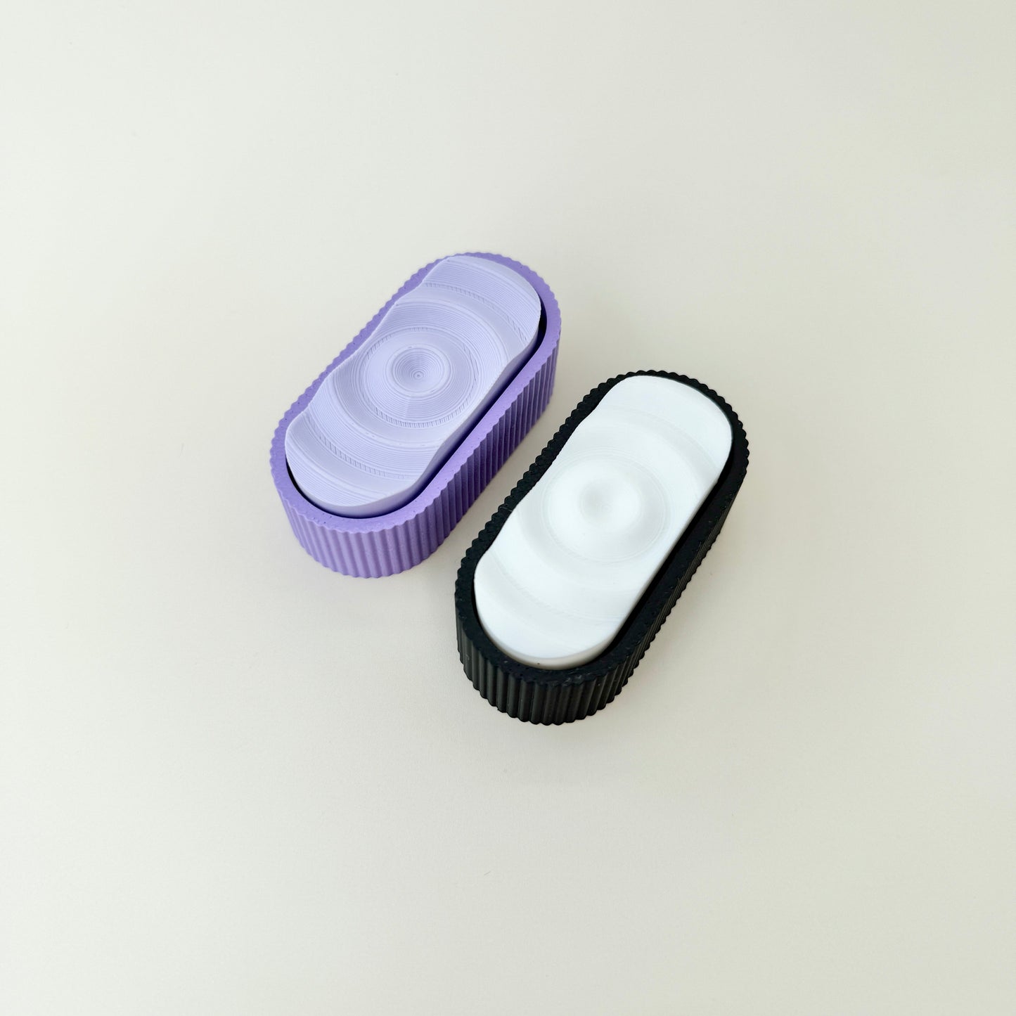 Triple-click fidget with ripple texture on top and textured grip around the edge.