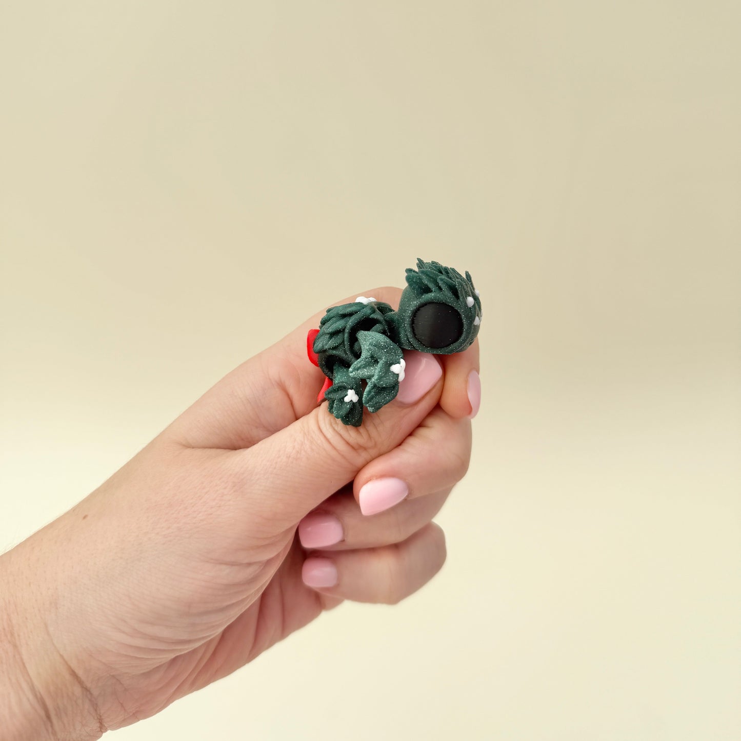 Compact glitter-green turtle with mistletoe-style texture and soft white dot accents for gentle thumb tracing.