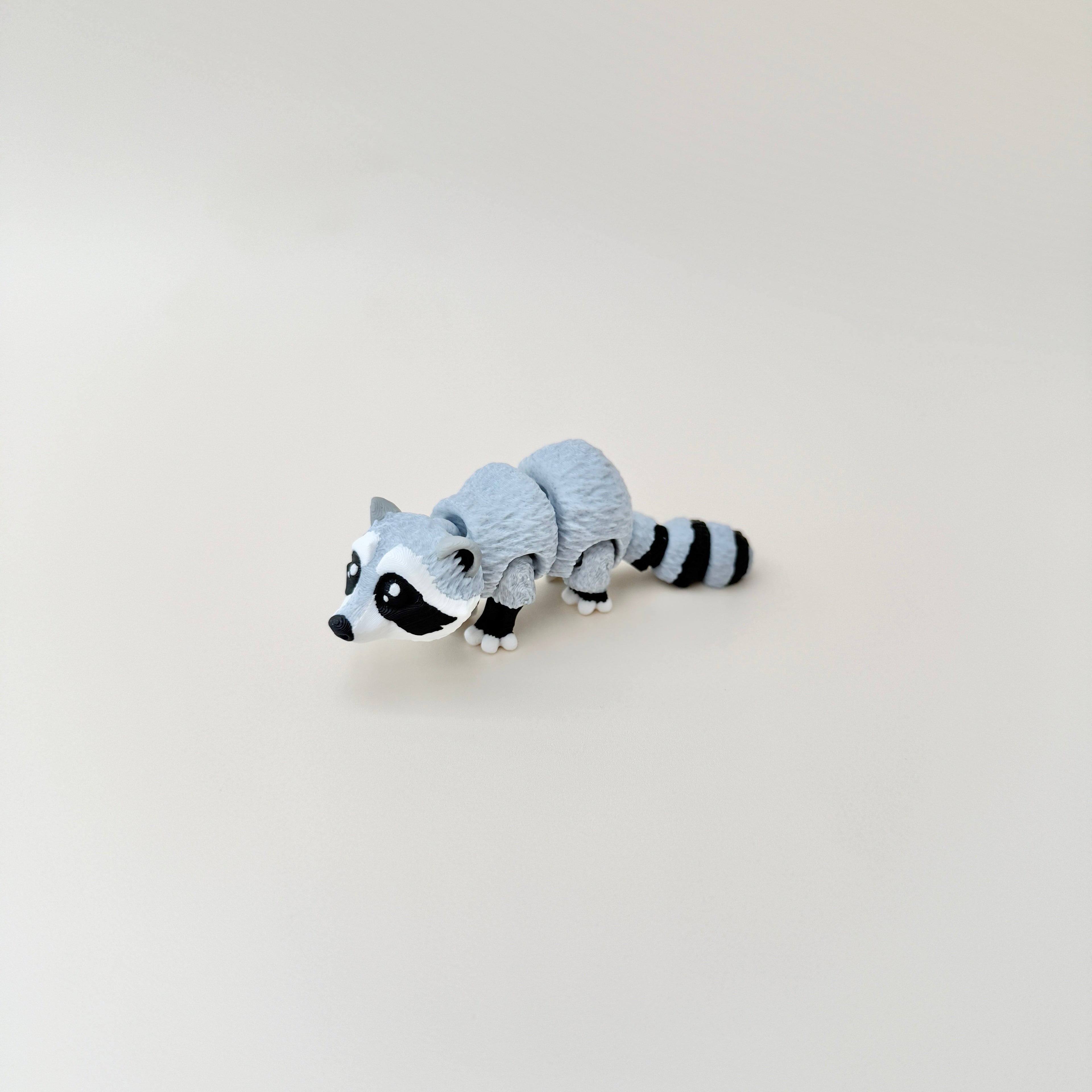 Handheld raccoon fidget toy with realistic design and articulated parts, perfect for fidgeting.