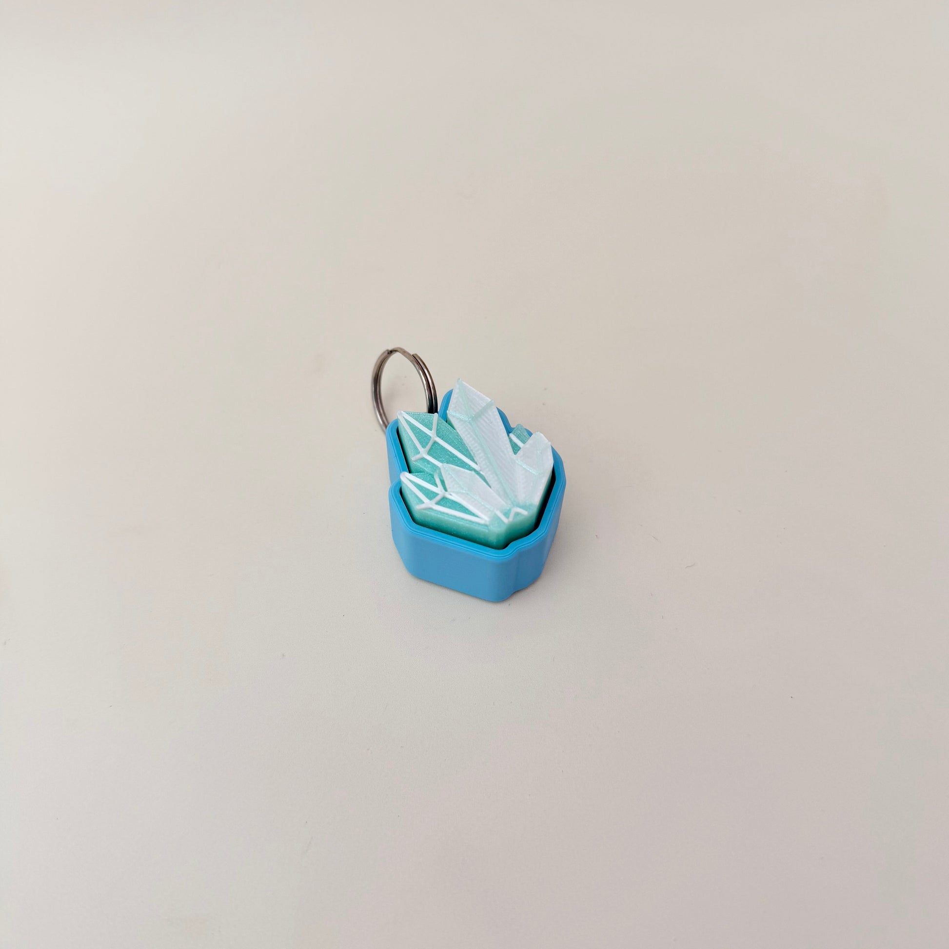 Shimmery crystal cluster clicker; tactile geometry for sensory input; attaches to keys, bags and lanyards.