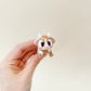 A small, flexible cow fidget toy with a cute farmyard design, ideal for fidgeting.