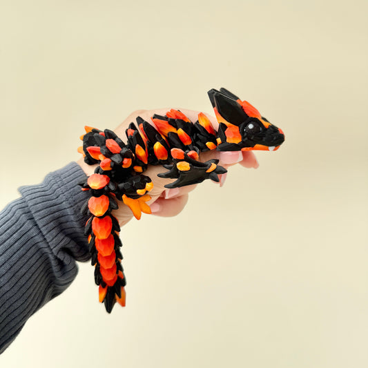 fully flexible dragon fidget with raised detailing and shimmering black eyes
