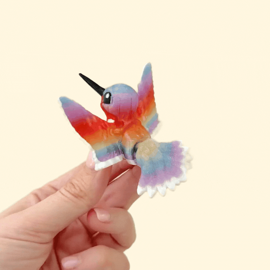 A detailed fidget toy designed to mimic a hummingbird in flight, with moving wings and tail