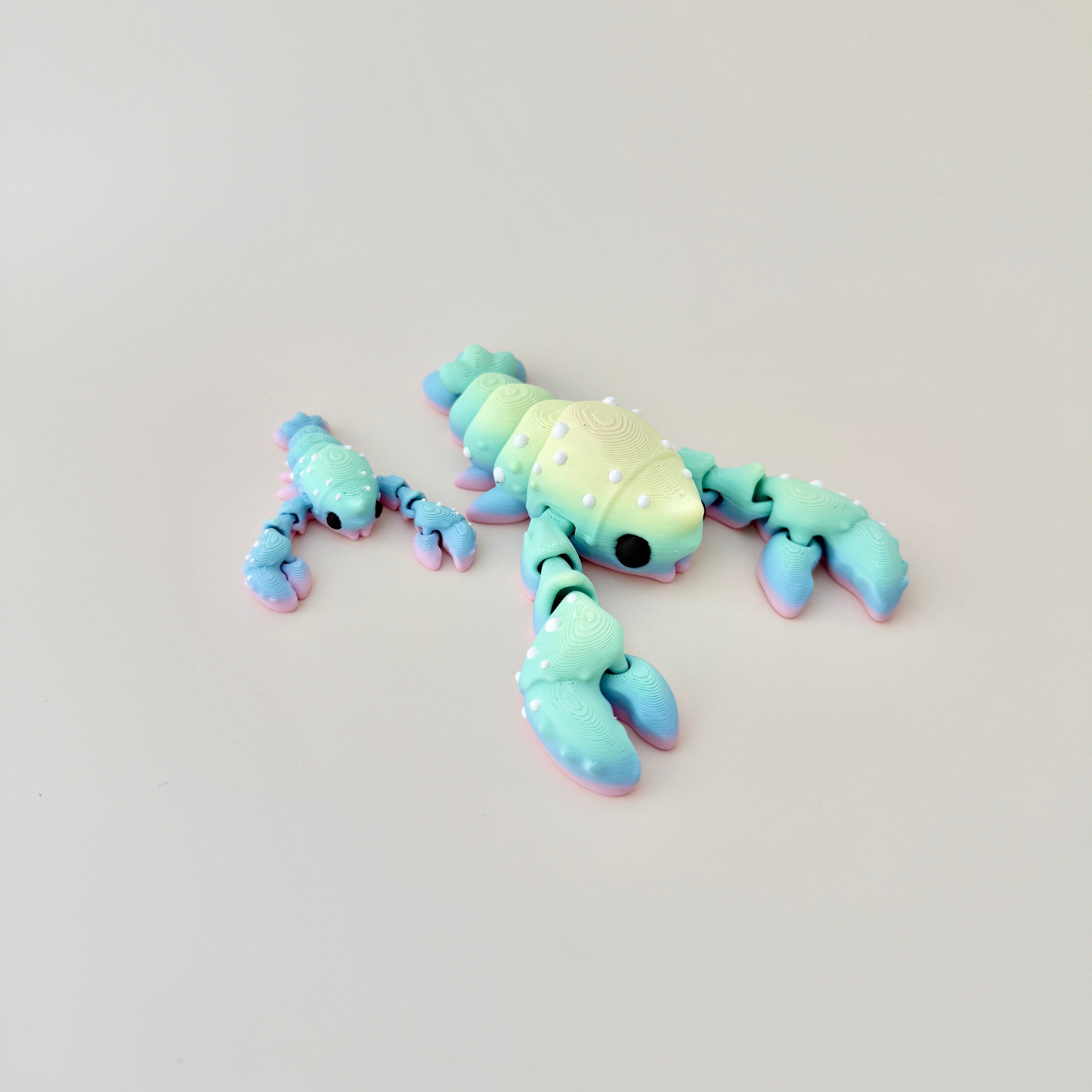 Lobster fidget toy available in red or rainbow, featuring flexible movement and sensory appeal.