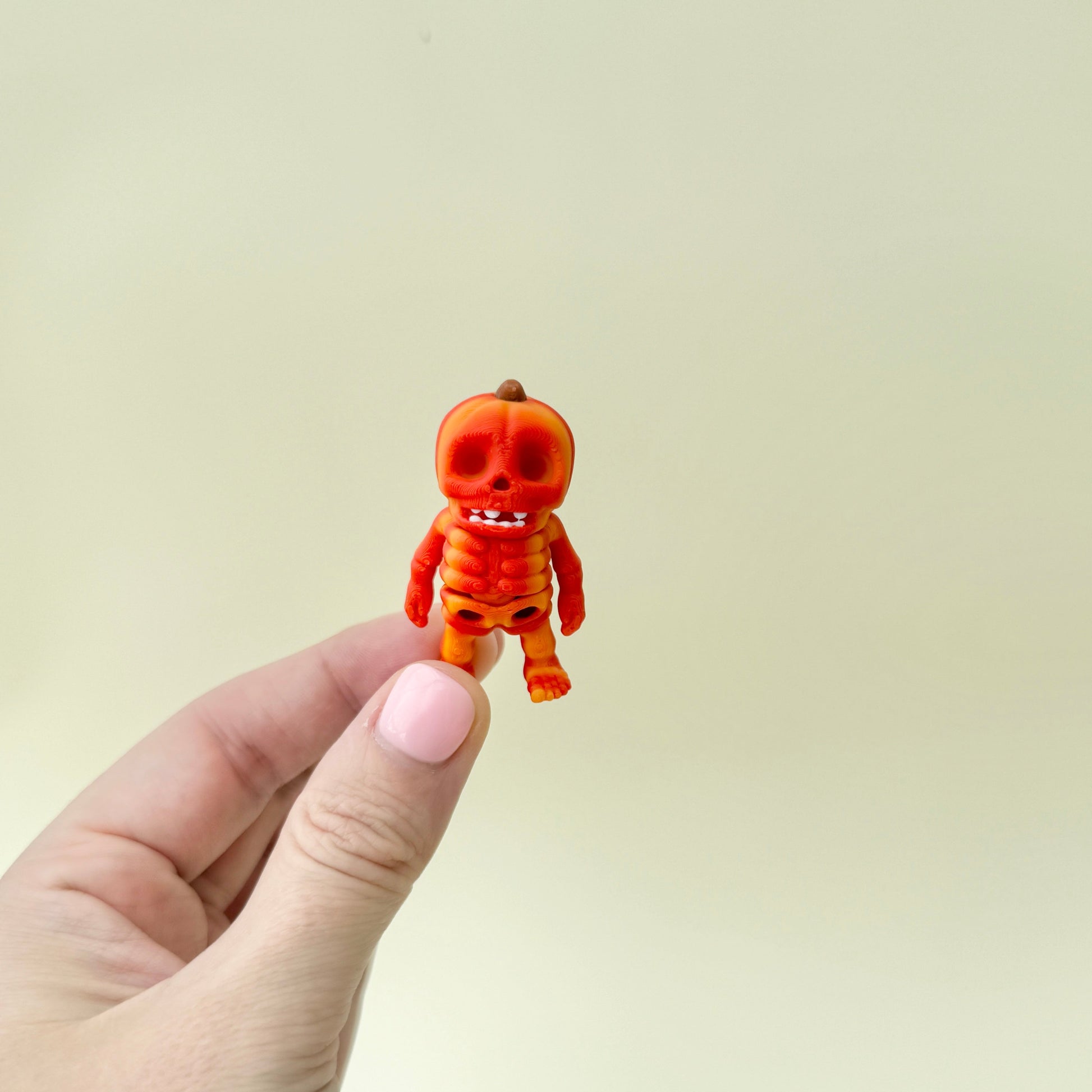 Miniature pumpkin-themed skeleton with detailed joints and textured design
